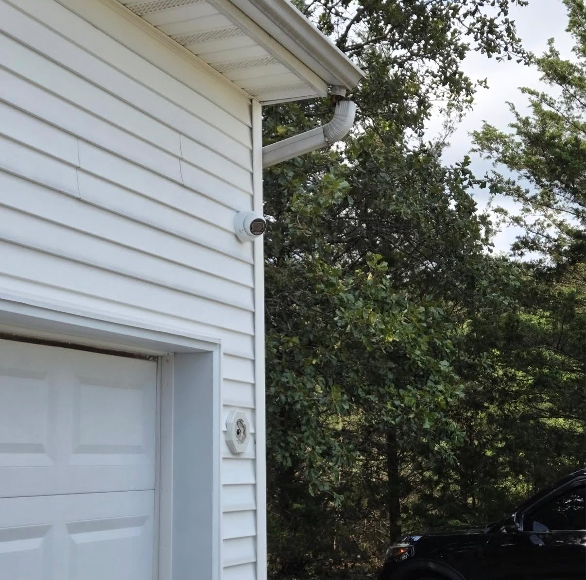 Security camera mounted on garage siding overlooking the driveway